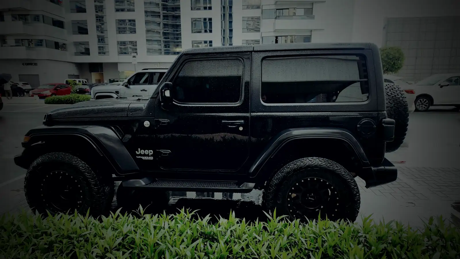 Jeep Wrangler negro con gotas de lluvia sobre la pintura
